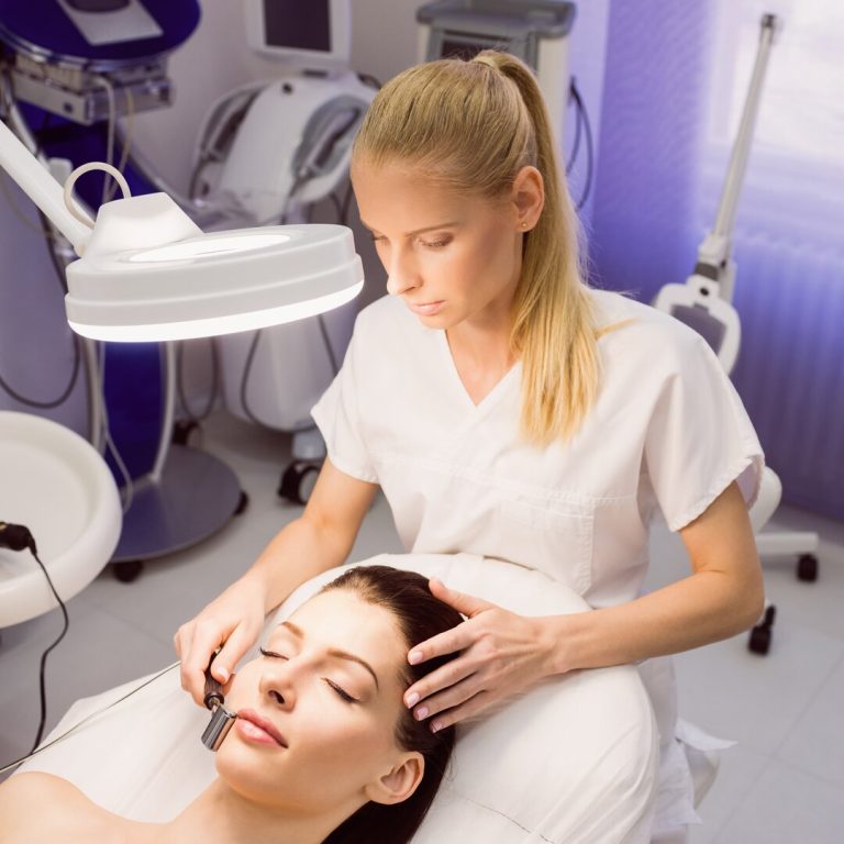 Dermatologist performing laser hair removal on patient