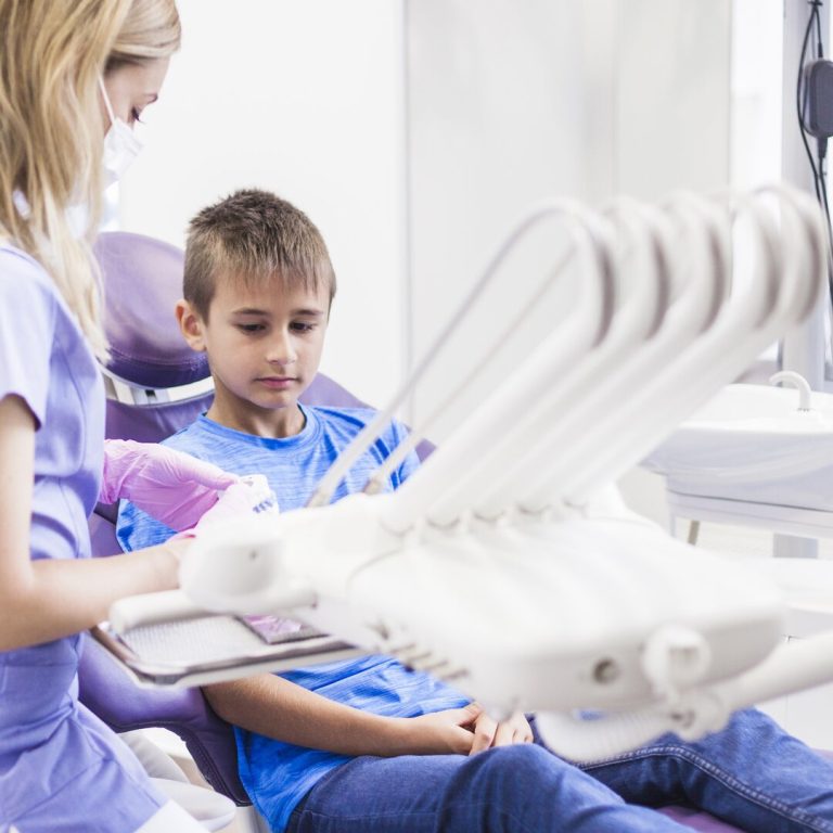 female-dentist-with-teeth-plaster-mold-sitting-near-child-patient-clinic (1)